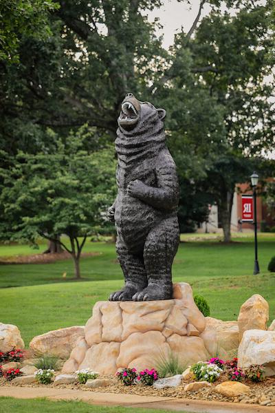 Standing bear sculpture with flowers